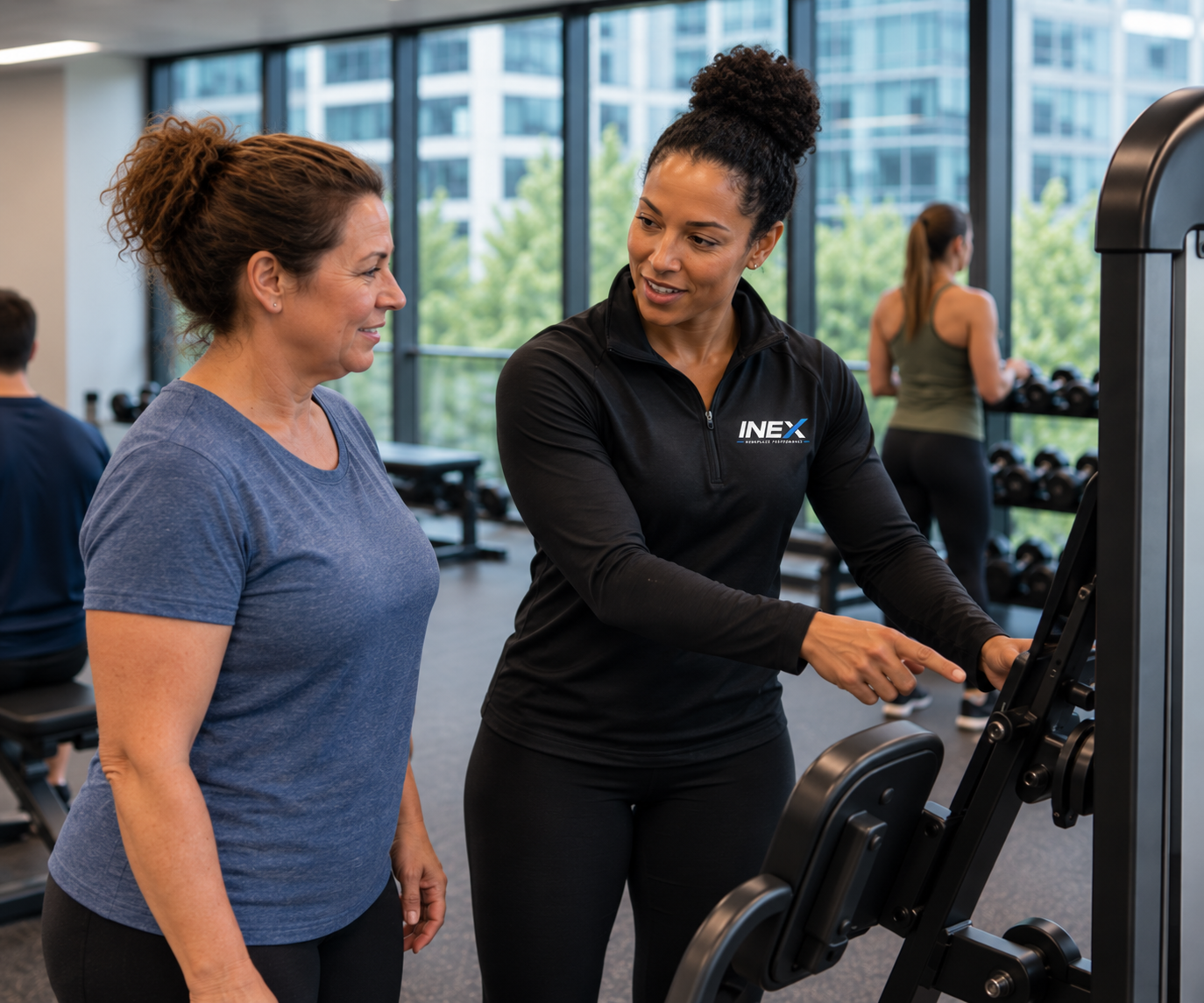 INEX coach helping an employee get comfortable with workplace fitness equipment